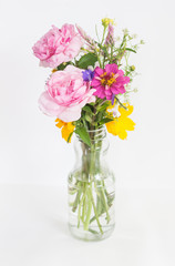 Beautiful flowers in glass vase on white background