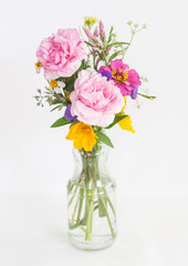 Beautiful flowers in glass vase on white background