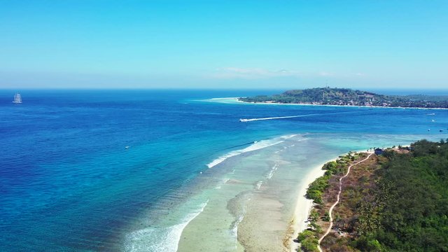 Aerial panorama, boat sailing between the tropical islands on a sunny day