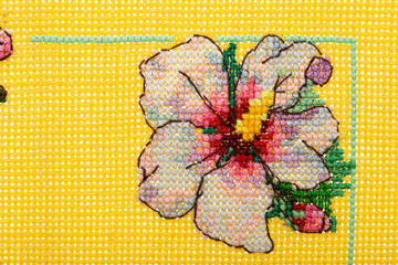 Ornament from embroidered flowers, cross-stitch on textile canvas