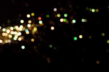 Gold glitter bokeh lights on black background, unfocused. Holiday time. overlay layer