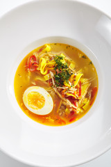 Chicken Soup with Tagliatelle Pasta, Eggs and Fresh Herbs Isolated
