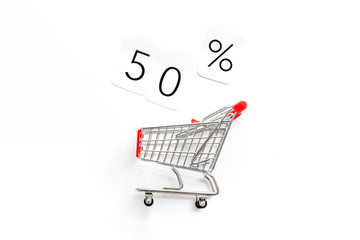 50% off discount - sale concept with shopping trolley cart - on white background top-down copy space
