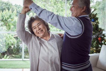 Happy couple old elderly senior man and woman dancing and happy with smiling together at home, retirement and healthcare lifestyle and lover relationship concept