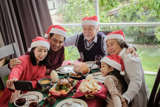 Big family selfie together after meal in Christmas day, they are happy and smiling during take photograph together, Asian family holiday concept, top view