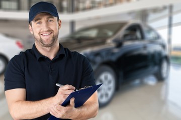 Delivery man with clipboard on light background