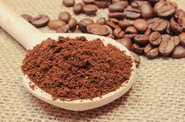 Ground and coffee grains with spoon on jute burlap