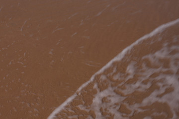 Fototapeta na wymiar The sea and the waves on the sandy beach