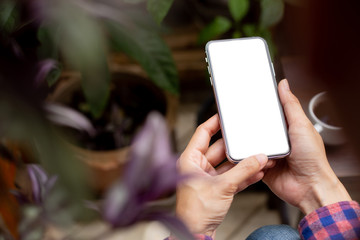Mockup image blank white screen cell phone.men hand holding texting using mobile on desk at home office.background empty space for advertise text.people contact marketing business and technology 
