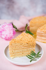 Delicious cake honey cake is on the table with flowers.