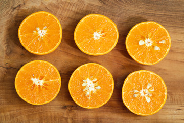A piece of mandarin orange fruit sliced with leaves on the golden teak floor And two orange juice glasses. As a background image.
