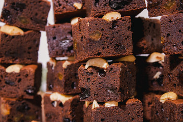 Homemade brownies using real butter, no baking powder, mixed with green, red raisins, chopped nuts, placed on a wooden tray With some ingredients, background.