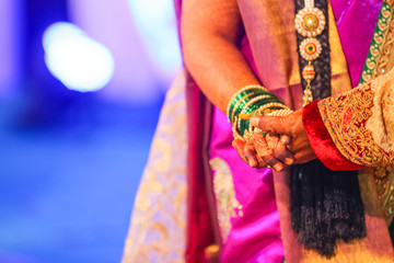 Fototapeta na wymiar Traditional indian wedding ceremony, groom holding hand in bride hand