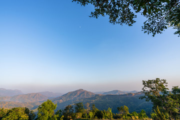 Fototapeta premium beautiful blue sky high peak mountains mist fog wildlife green forest at Khao Koh Phu Tub Berk Phetchabun Thailand guiding idea long weekend for backpacker camping hiking 