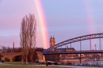 Ein farbenprächtiger Regenbogen steht neben dem Magdeburger Dom. 