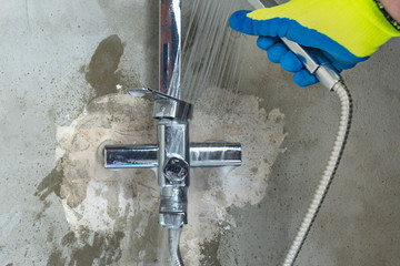 a man in yellow gloves washes a faucet in the bathroom, applies special cleaning products. close-up.