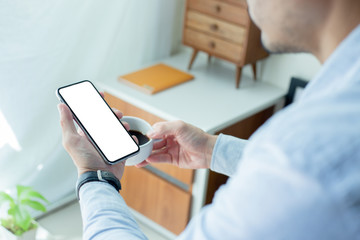 Mockup image blank white screen cell phone.men hand holding texting using mobile on desk at home office.background empty space for advertise text.people contact marketing business,technology 