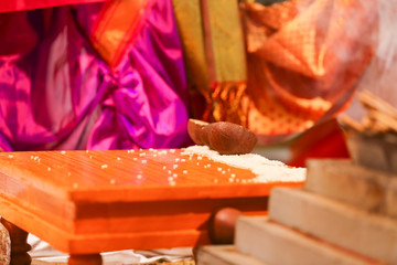 Indian wedding ceremony :Decorative wooden board with rice grain and coconut for haldi ceremony 