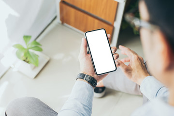 Mockup image blank white screen cell phone.men hand holding texting using mobile on desk at home office.background empty space for advertise text.people contact marketing business,technology 