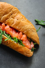 fish sandwich and greens, Smorrebrod (salted salmon, croissant, bread, arugula and other ingredients) menu concept. food background. top view. copy space