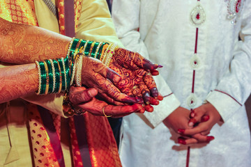 Traditional indian wedding ceremony, groom holding hand in bride hand