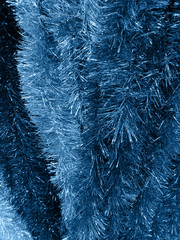Tinsel garland toned classic blue color - Christmas background