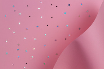 Pastel pink paper in geometric shape with glitter stars. Abstract Christmas, New year, festive background