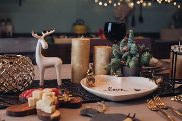 Photo of Christmas table decoration with festive dinnerware with candles. New Year eve concept