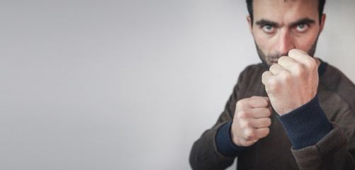 Caucasian aggressive man threatening with fists.