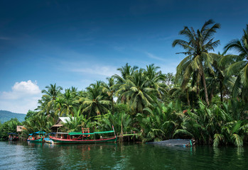 traditional jungle boat at pier on tatai river in cambodia - obrazy, fototapety, plakaty