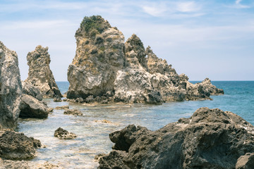 Fototapeta na wymiar Sea rocks in tidal aves along Ionian sea coast in Paleokastritsa resort in June. Corfu Island, Greece