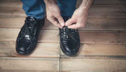 Man tying laces of shoes.