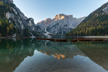 Natural landscapes of the lake Braies (Lago di Braies) with morning fog and reflection of the mountain peak in Dolomites, Italy