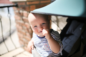 baby sitting stroller under peak from sun