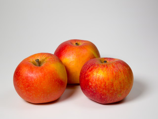 three red and yellow apples isolated on a white background