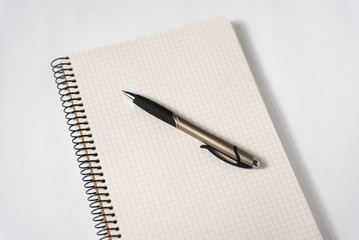 Pen on a blank page of an open notebook. White background. Creativity, muse, plans