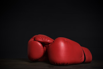 Pair of red boxing gloves on a black background. Copy space