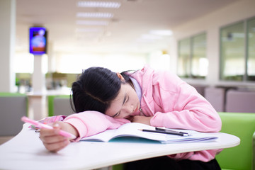 Students are asleep after reading a book, reviewing lessons before the exams heavily.