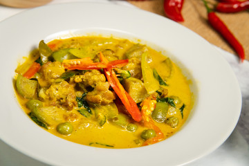 Green curry traditional Thai food name in Thai is Gaeng Kiew Waan in white round ceramic plate