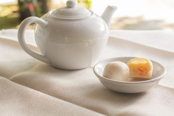 side view white pot of hot coffee  served with two small mooncake on table with vintage tone. Break times concept.
