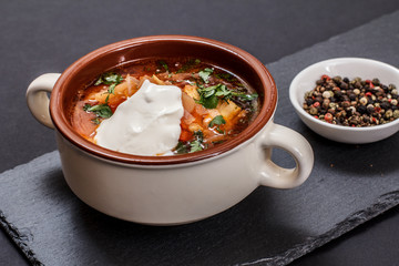Ukrainian traditional borsch with allspices on black background.