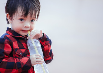 A children drinking water from straw.