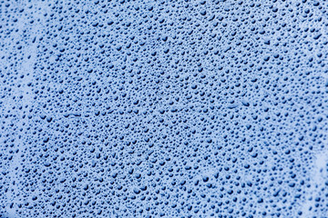 Blue surface with drops of rain water