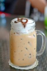 Close up ice coffee with milk froth in mug at cafe and restaurant. Baverage for freshness. Break times.