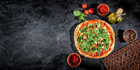 Traditional Italian pizza, vegetables, ingredients on a dark background. Top view with copy space. Pizza menu