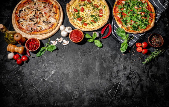 Traditional Italian pizza, vegetables, ingredients on a dark background. Top view with copy space. Pizza menu
