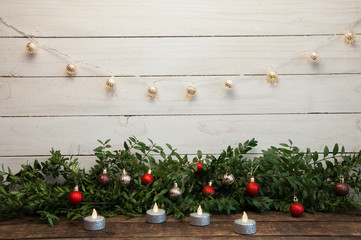 New Year and Christmas background with candles. Wood texture and garland.