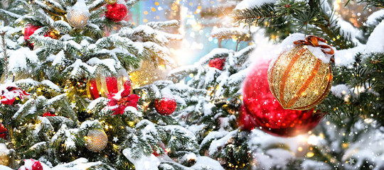 Christmas and New Year background.  bright balls and decor on Christmas tree, snowy backdrop. festive winter holidays season concept. template for design. banner, copy space
