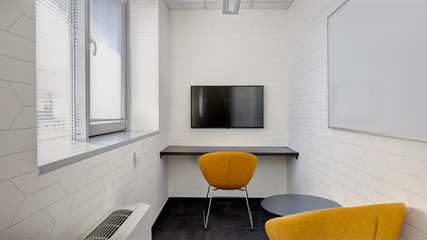 office room with monitor and yellow chairs
