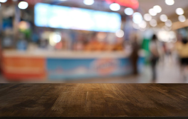 Empty dark wooden table in front of abstract blurred bokeh background of restaurant . can be used for display or montage your products.Mock up for space.